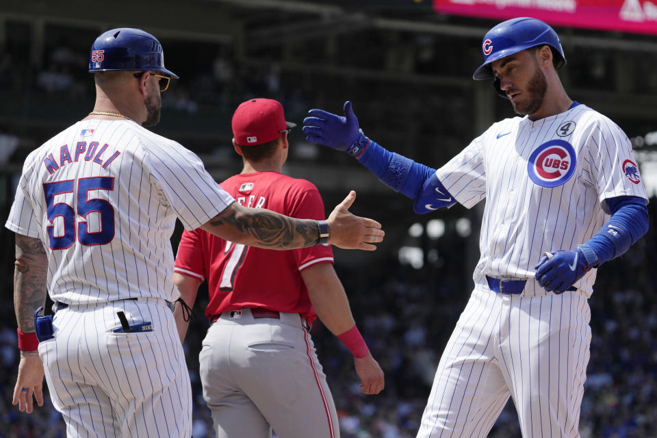 Chicago Cubs' Cody Bellinger, right, celebrates with first base coach Mike Napoli, left, after hitting a one-run single during the fifth inning of a baseball game against the Cincinnati Reds in Chicago, Sunday, June 2, 2024. (AP Photo/Nam Y. Huh)