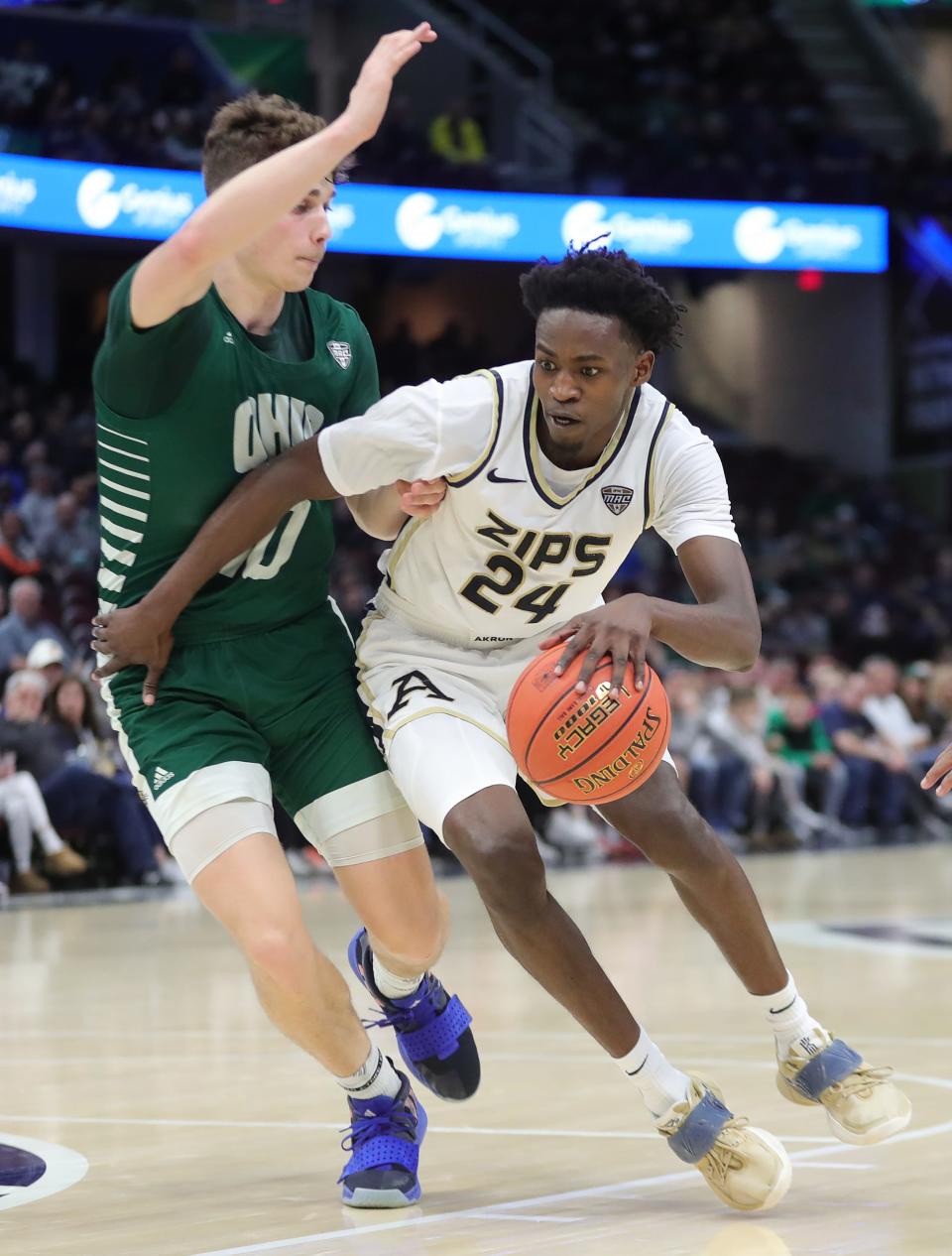 Akron Zips guard Ali Ali (24) drives against Ohio Bobcats forward Aidan Hadaway (10) during the second half of an NCAA college basketball game in the semifinals of the Mid-American Conference Tournament at Rocket Mortgage FieldHouse, Friday, March 15, 2024, in Cleveland, Ohio.