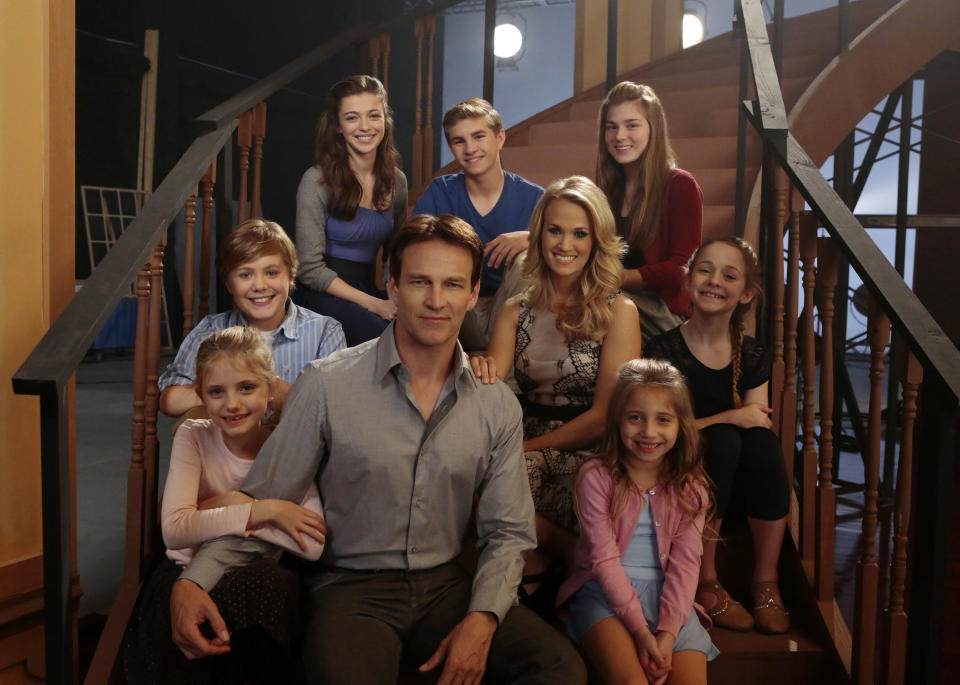 This image released by NBC shows Stephen Moyer as Captain Von Trapp, foreground center, and Carrie Underwood as Maria, second row center, with fellow castmates, clockwise from left, Grace Rundhaug as Marta, Joe West as Kurt, Ariane Rinehart as Liesl, Michael Nigro as Friedrich, Ella Watts-Gorman as Luisa, Peyton Ella as Gretl, Peyton Ella as Gretl on the set of The Sound of Music Live! in New York. The live production airs on Dec. 5 at 8 p.m. EST. (AP Photo/NBC, Giovanni Rufino)