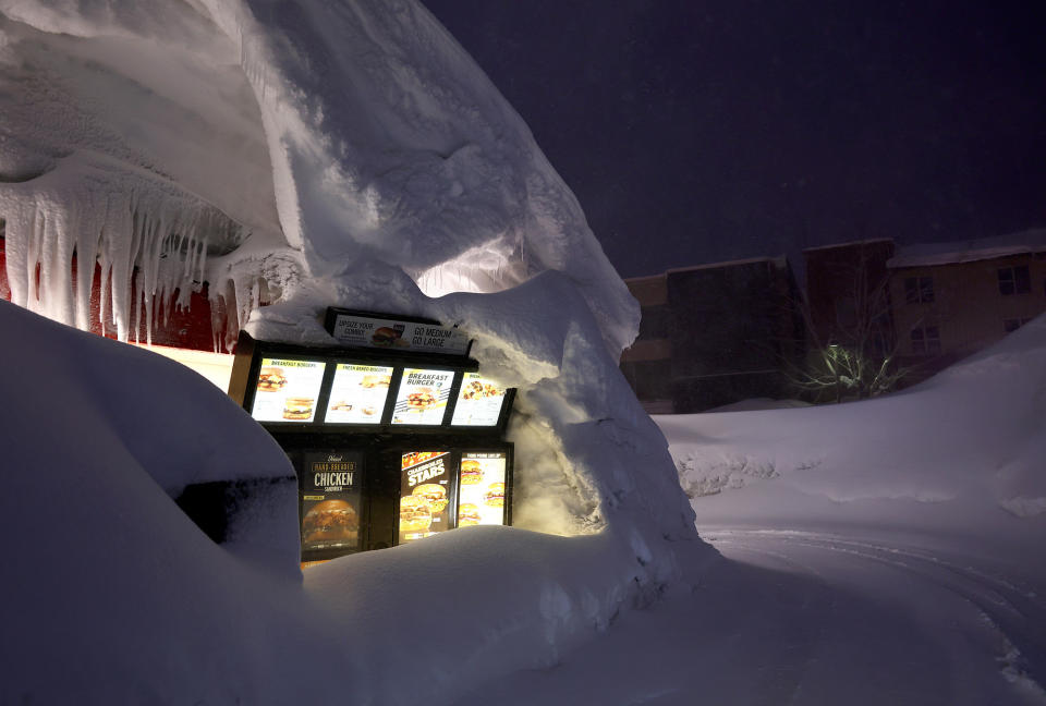 A Carl's Jr. drive-through menu is partially buried in a snowbank in Mammoth Lakes, California, on March 11, 2023.