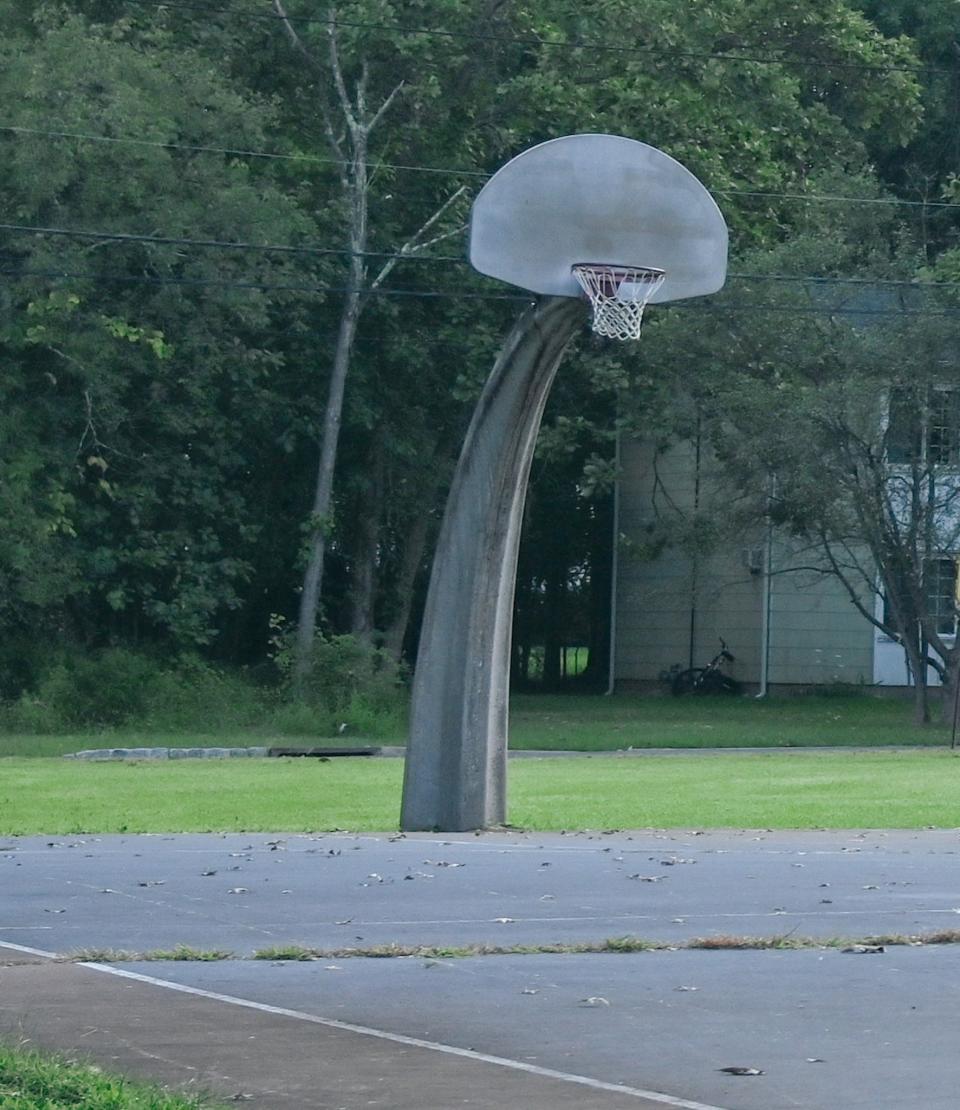 Grass grows through the cracks of the basketball court at David and Phillip Miller Park in Bridgewater's Hobbstown section.