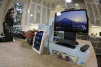 In this photo taken Tuesday, Sept. 17, 2019, new Facebook Portal products are displayed during an event in San Francisco. At left being demonstrated is the Portal Mini and at right is Portal TV. Facebook is slashing the price and the size of the Portal, its screen and camera-equipped gadget for making video calls with friends and family as it attempts to get the device into more homes. A smaller version will now cost $129 and have an 8 inch display. A larger version will cost $179 and have a 10 inch display. (AP Photo/Eric Risberg)