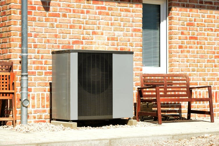 Air heat pump for heating and hot water in front of an apartment building.