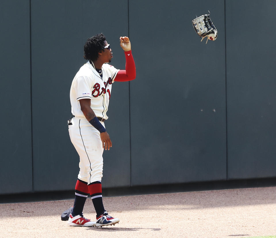 Atlanta Braves outfielder Ronald Acuna Jr. tosses his glove after losing a three-run home run by Los Angeles Dodgers' Cody Bellinger during the first inning of a baseball game Sunday, Aug. 18, 2019, in Atlanta. (Curtis Compton/Atlanta Journal-Constitution via AP)