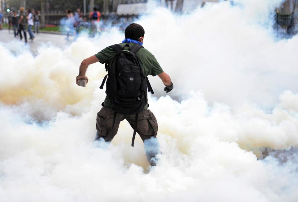 FILE - In this May 31, 2013, file photo, riot police use tear gas and pressurized water to quash a peaceful demonstration by hundreds of people staging a sit-in protest to try and prevent the demolition of trees at Gezi Park in Istanbul, Turkey. During the height of Turkey's summer of upheaval, more than a dozen Turkish doctors interviewed by The Associated Press say authorities assaulted them with tear gas, pressured them to reveal the names of patients and ignored calls for resources. (AP Photo/Emrah Gurel, File)