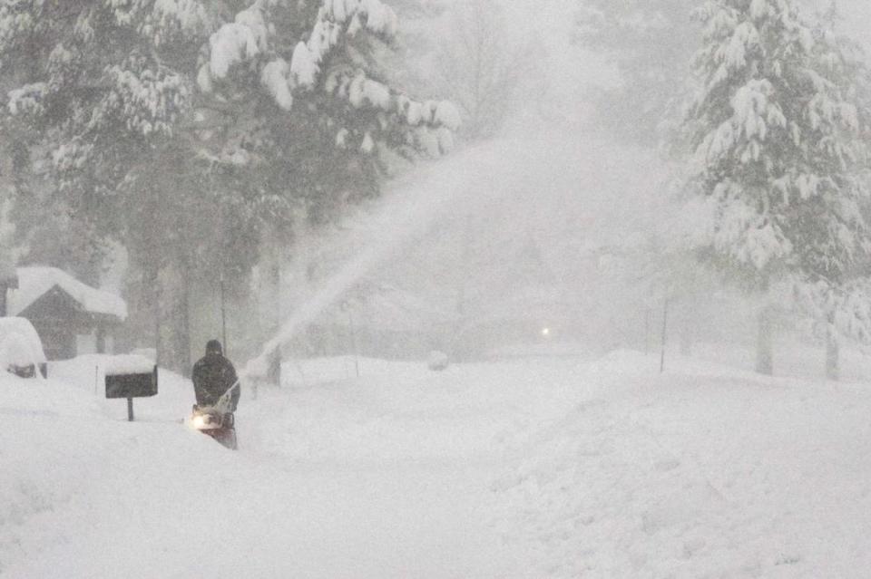 A person uses a snow blower to clear snow from a driveway during a storm, Saturday, March 2, 2024, in Truckee, Calif. A powerful blizzard howled Saturday in the Sierra Nevada as the biggest storm of the season shut down a long stretch of Interstate 80 in California and gusty winds and heavy rain hit lower elevations, leaving tens of thousands of homes without power.