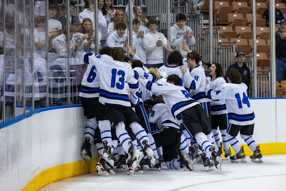 Members of the Oyster River boys hockey team celebrate with the student section following Saturday's 3-0 win over Spaulding in the Division II state championship game at Southern New Hampshire University Arena in Manchester.