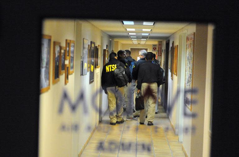 Members of the National Transportation Safety Board (NTSB) arrive before dawn at the Mojave Air and Space Port in California on November 1, 2014