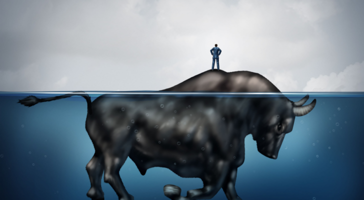 An image of a lost businessman on an island as a bull underwater; hidden bull market, bull markets