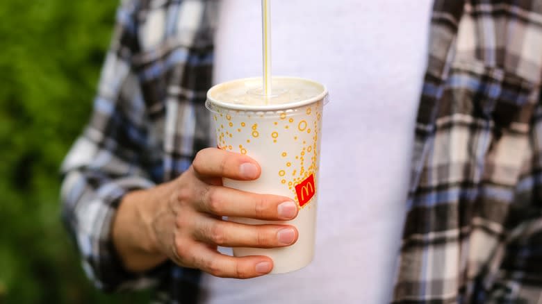 person holding a Mcdonald's cup