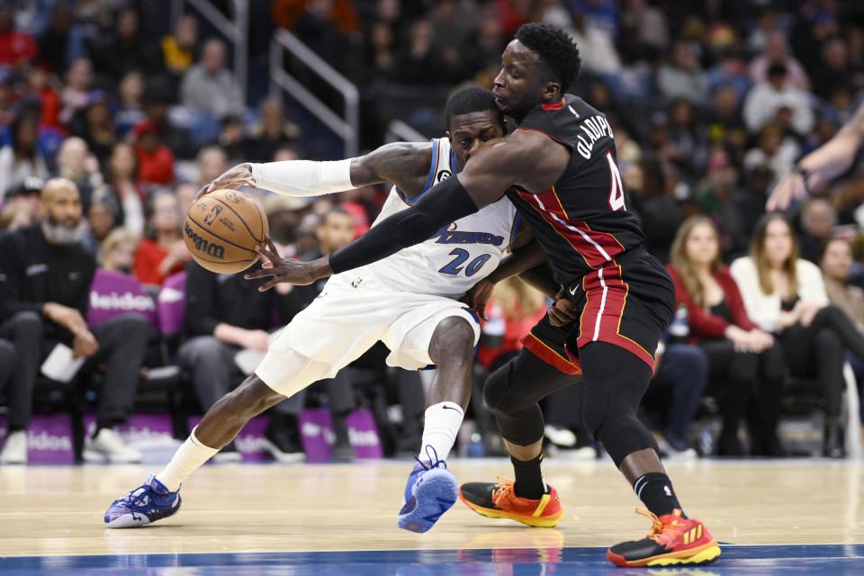 Miami Heat guard Victor Oladipo (4) reaches for the ball against Washington Wizards guard Kendrick Nunn (20) during the first half of an NBA basketball game Friday, April 7, 2023, in Washington. (AP Photo/Nick Wass)
