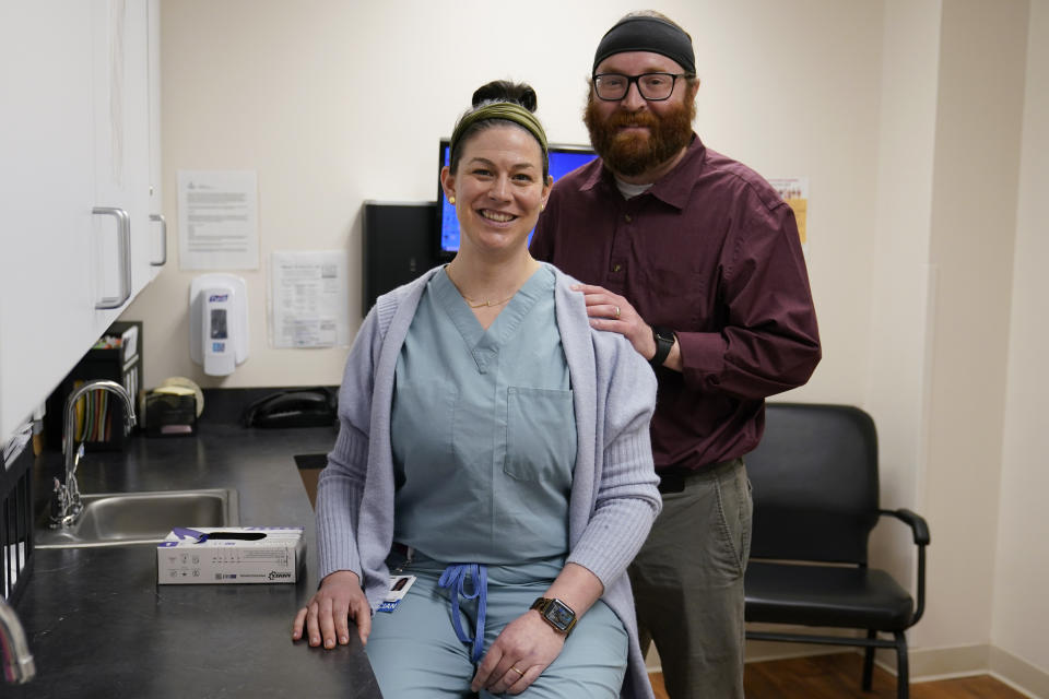 Dr. Caitlin Robinson, D.O., left, and her husband Stephen J. Robinson, M.D., right, pose for a photo at a Chesapeake Health Care office in Salisbury, Md., Thursday, March 2, 2023. (AP Photo/Susan Walsh)