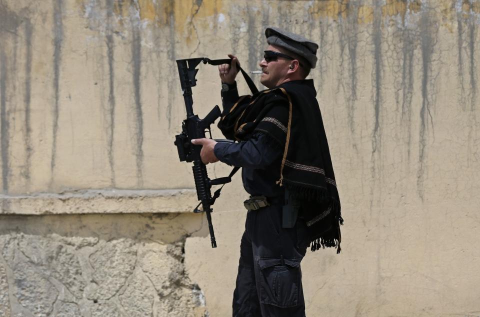A foreign security guard prepares his weapon at the gate of Cure Hospital after three Americans were killed in Kabul April 24, 2014. (REUTERS/Omar Sobhani)