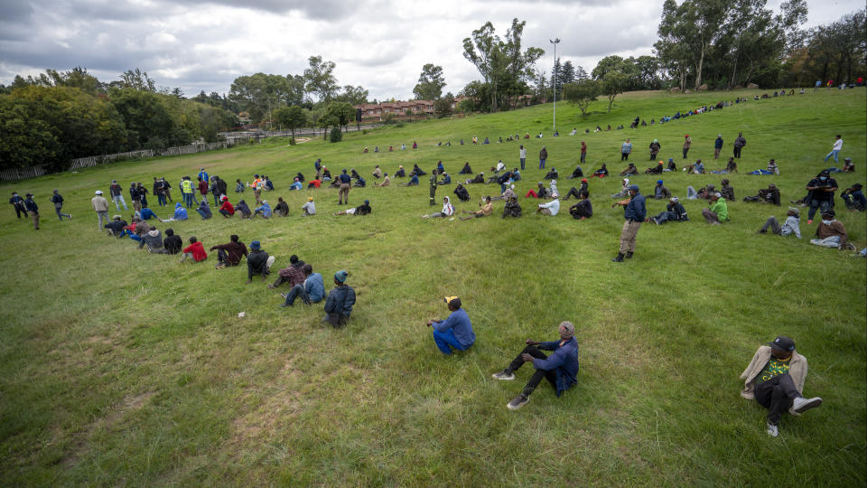 Homeless recyclers and other destitute people, some of whom said they have not eaten in three days, practice social distancing as they lineup in a Johannesburg park, waiting to receive food baskets from private donors, Thursday, April 9, 2020. Because of South Africa's imposed lockdown to contain the spread of COVID-19, many people who don't have savings and are unable to work are not able to buy food. (AP Photo/Jerome Delay)