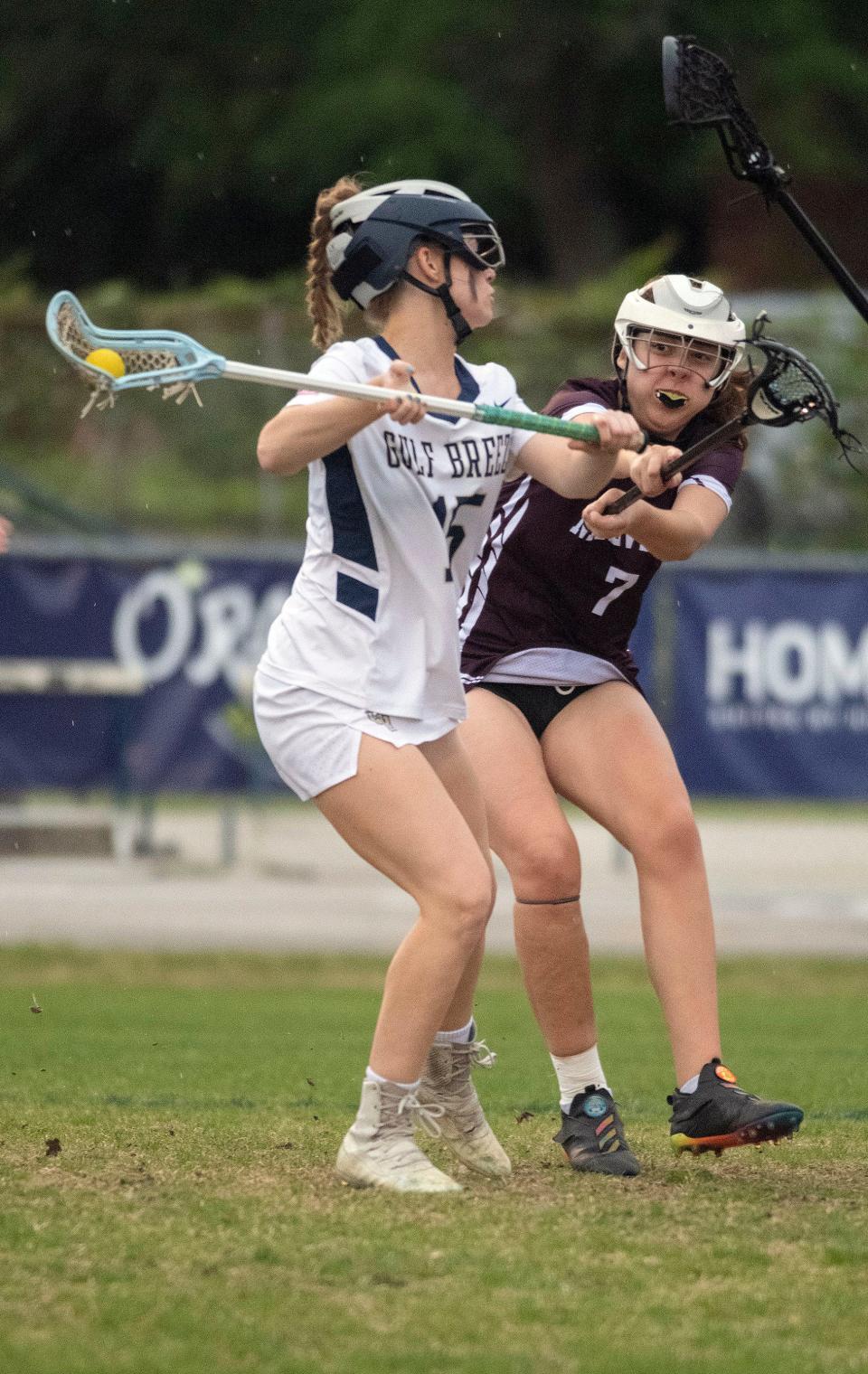 Gulf Breeze High School's Sarah Kemp (No. 15) takes on Niceville defender Ella Krebsbach (No. 7) during the girls' lacrosse district match on Wednesday, April 12, 2023. 