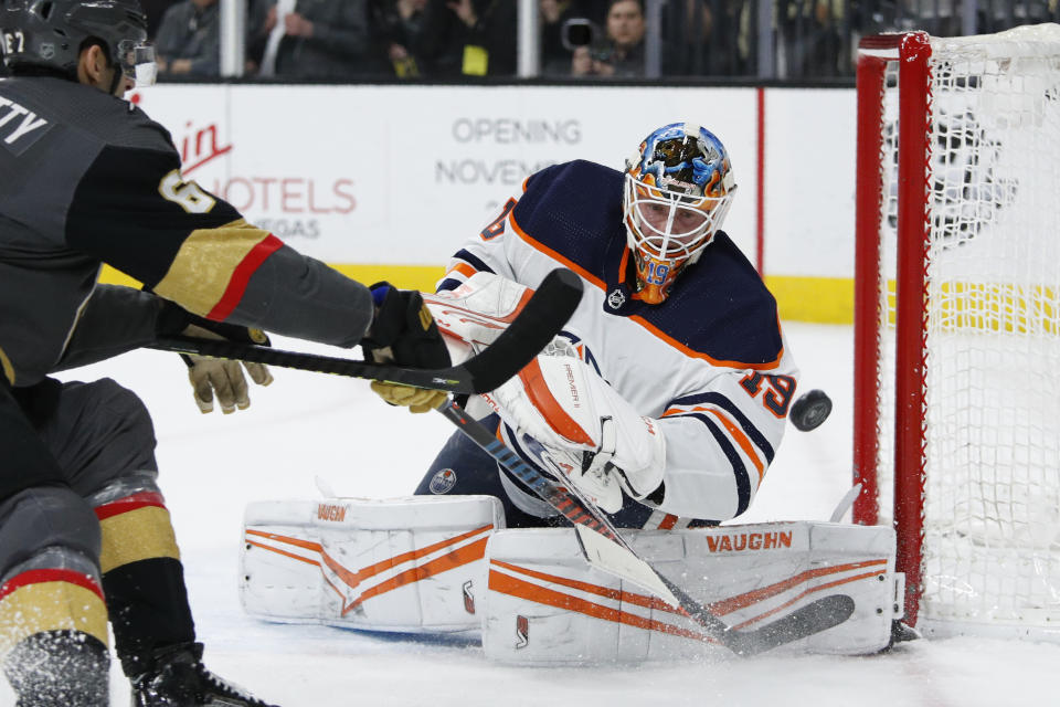 Edmonton Oilers goaltender Mikko Koskinen (19) knocks the puck away from the Vegas Golden Knights during the second period of an NHL hockey game Wednesday, Feb. 26, 2020, in Las Vegas. (AP Photo/John Locher)