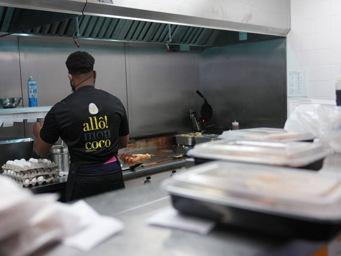 A worker prepares takeout orders at the Allô! Mon Coco restaurant in Gatineau, Que. Indoor dining returns in Quebec as of Monday, Jan. 30. (Felix Desroches/Radio-Canada - image credit)