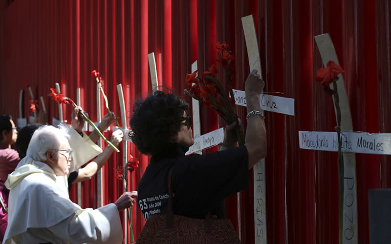 Relatives of miners who died in various mine accidents place flowers on crosses