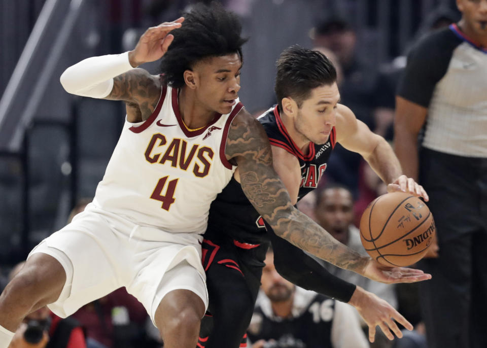 Cleveland Cavaliers' Kevin Porter Jr. (4) and Chicago Bulls' Ryan Arcidiacono (51) compete for the ball during the first half of an NBA basketball game Wednesday, Oct. 30, 2019, in Cleveland. (AP Photo/Tony Dejak)