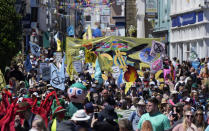 Activists march through the streets with banners and signs during a demonstration around the meeting of the G7 in Falmouth, Cornwall, England, Saturday, June 12, 2021. Leaders of the G7 gather for a second day of meetings on Saturday, in which they will discuss COVID-19, climate, foreign policy and the economy. (AP Photo/Alastair Grant)