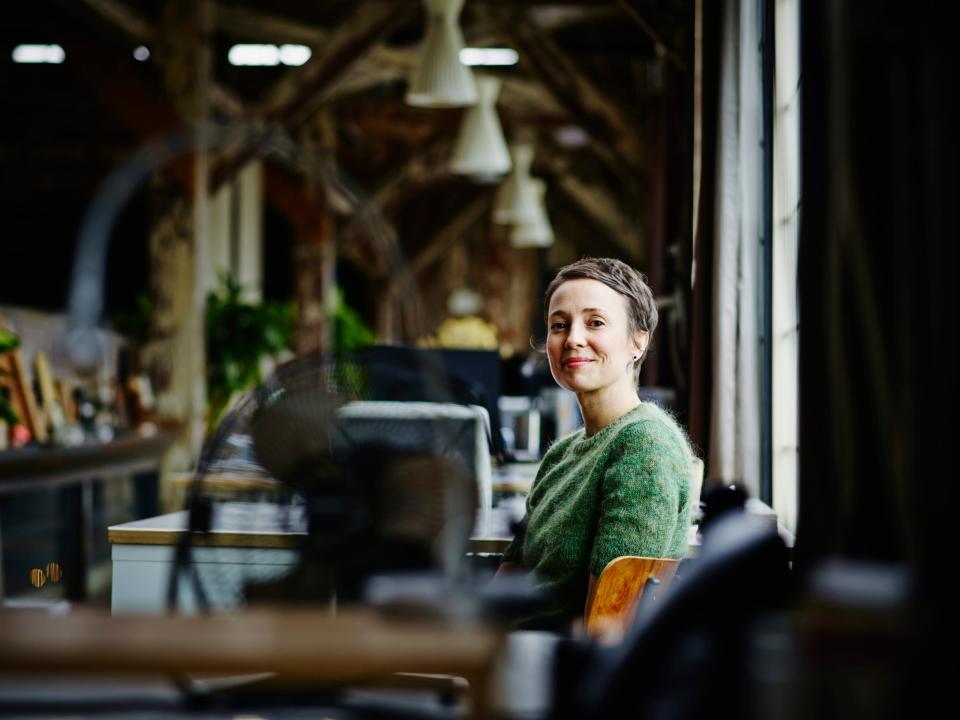 Smiling businesswoman sitting at workstation in design firm