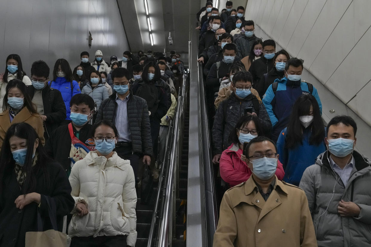 Commuters rush to catch their trains at a subway station during the morning rush hour in Beijing on Monday, Nov. 14, 2022. (AP Photo/Andy Wong)