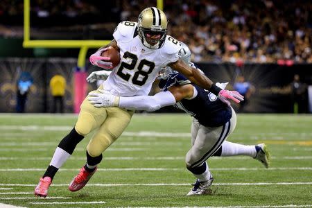 Oct 4, 2015; New Orleans, LA, USA; New Orleans Saints running back C.J. Spiller (28) carries the ball past Dallas Cowboys cornerback Byron Jones (31) during the second half at the Mercedes-Benz Superdome. Derick E. Hingle-USA TODAY Sports