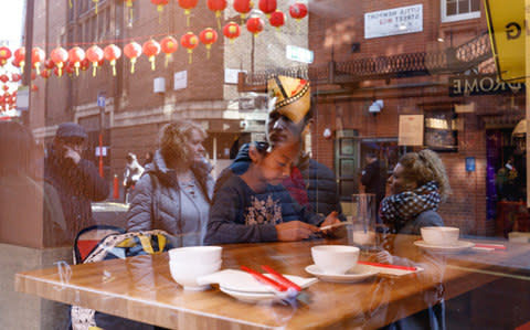 Young girl playing on her smart phone in a cafe in London's Chinatown. - Credit: Edward Robertson/This Is Britain