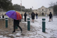 Snow begins to accumulate as San Antonio police officers gather near the Alamo, Thursday, Feb. 18, 2021, in downtown San Antonio. Snow, ice and sub-freezing weather continue to wreak havoc on the state's power grid and utilities. (AP Photo/Eric Gay)