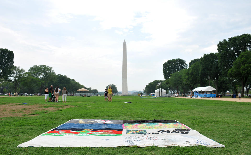 In this photograph taken by AP Images for AIDS Healthcare Foundation, the last panel of the AIDS quilt lays on the ground with the Washington Monument in the background during the closing of the AIDS quilt memorial, Tuesday, July 24, 2012, in Washington. The AIDS quilt memorial is being put away but not forgotten. (Larry French/AP Images for AIDS Healthcare Foundation)