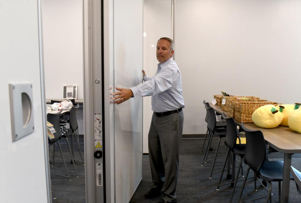 Tim Walker,  Director of Development and Special Projects. with North Canton City Schools demonstrates a wall of white boards that can close to seperate classrooms at North Canton Intermediate School, one of the districts two new buildings as they prepares to begin the school year.  Monday, August 21, 2023.