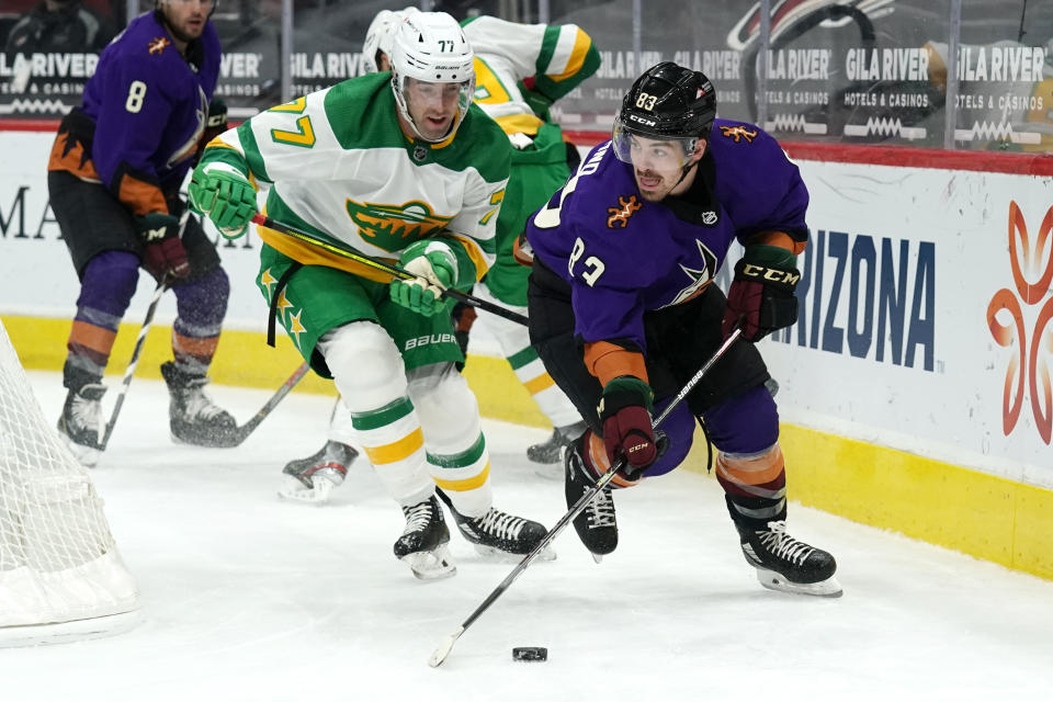 Arizona Coyotes right wing Conor Garland (83) shields the puck from Minnesota Wild defenseman Brad Hunt (77) in the second period during an NHL hockey game, Saturday, March 6, 2021, in Glendale, Ariz. (AP Photo/Rick Scuteri)