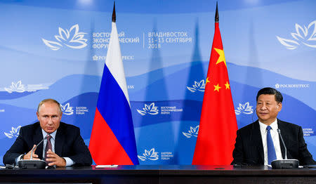 Russian President Vladimir Putin and Chinese President Xi Jinping attend a meeting with participants of a round table discussion on Russia-China Cooperation on the sidelines of the Eastern Economic Forum in Vladivostok, Russia September 11, 2018. Donat Sorokin/TASS Host Photo Agency/Pool via REUTERS