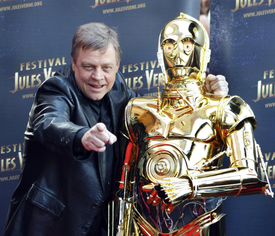 FILE - In this April 23, 2010 file photo, American actor Mark Hamill who played Luke Skywalker in the George Lucas Star Wars saga poses with a figure of the movie, C 3 PO, before the screening of "Star Wars V-The Empire Strikes Back," as part of the Jules Verne Festival in Paris. After months of carefully guarded secrecy and endless Internet speculation, the cast of the latest incarnation of the space epic, "Star Wars: Episode VII," was unveiled Tuesday, April 29, 2014, on the official "Star Wars" website by Lucasfilm and the Walt Disney Co. The "Episode VII" cast is a mix of fresh faces, up-and-comers and established names, including veterans Harrison Ford, Hamill and Carrie Fisher. (Photo/Remy de la Mauviniere, file)