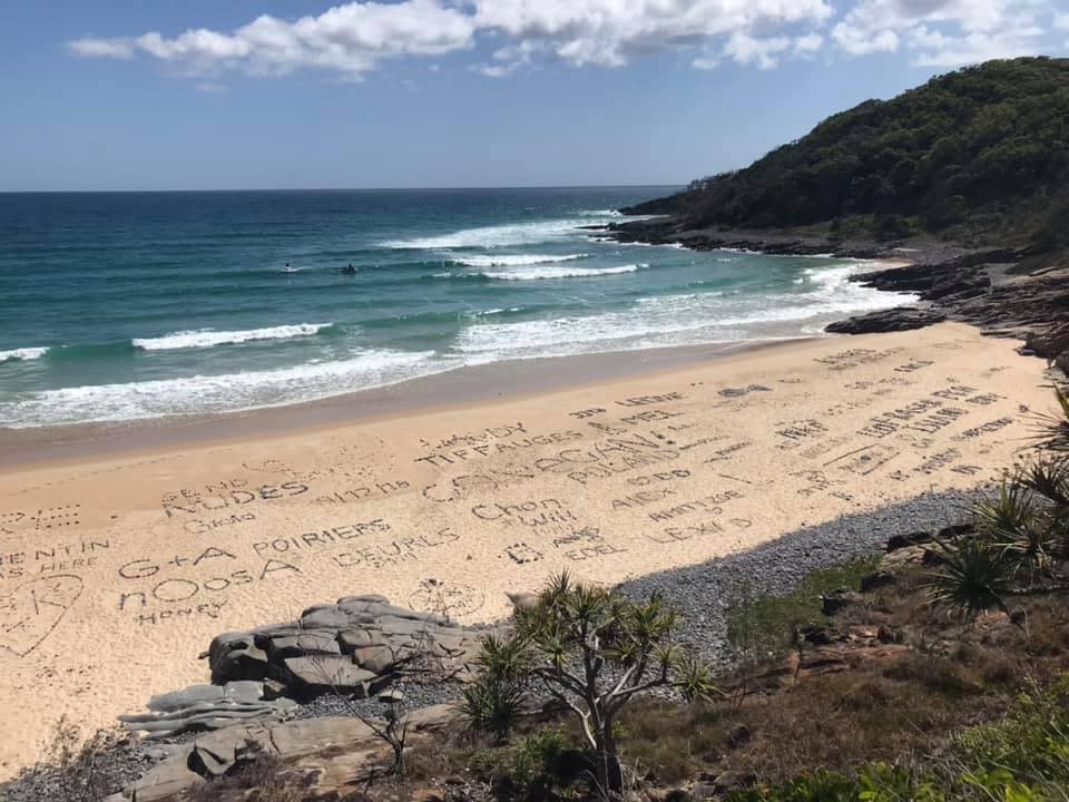 Beach covered in rock writing can be seen.