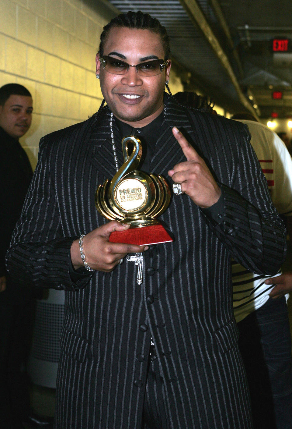 Don Omar in a suit holding an award he won from his album "Last Don"