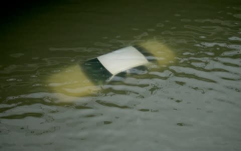 A car is submerged on a freeway flooded by Tropical Storm Harvey  - Credit: AP