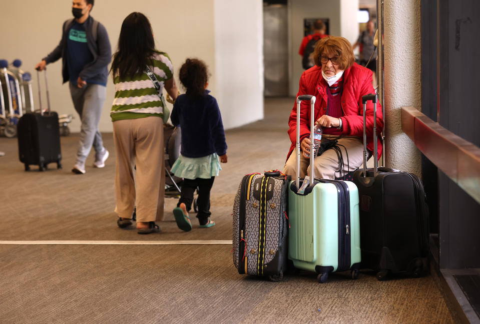 A traveler sits with her luggage at San Francisco International Airport on May 12, 2022 in San Francisco, California. According to a report by the Bureau of Labor Statistics, airline fares surged 18.6% in April as demand for air travel has increased due to COVID-19-related travel restrictions being eased. (Photo by Justin Sullivan/Getty Images)