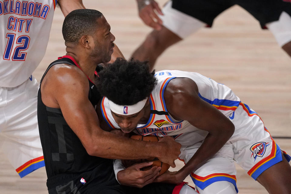Houston Rockets' Eric Gordon, left, and Oklahoma City Thunder's Shai Gilgeous-Alexander, right, wrestle for control of the ball during the second half of an NBA first-round playoff basketball game in Lake Buena Vista, Fla., Wednesday, Sept. 2, 2020. (AP Photo/Mark J. Terrill)