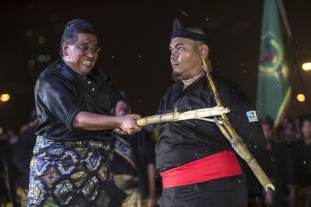 Malaysia's National Silat Federation (Pesaka) members break sugarcane during a demonstration at the National Silat Federation Assembly 2015 in Kuala Lumpur, Malaysia September 18, 2015. REUTERS/Ahmad Yusni