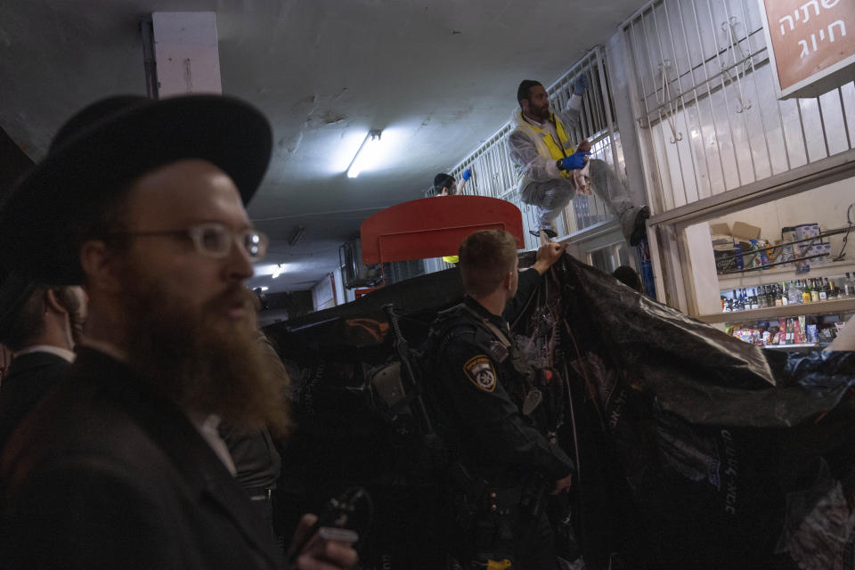 A member of Israeli Zaka Rescue and Recovery team cleans blood from the site where a gunman opened fire in Bnei Brak, Israel, Tuesday, March 29, 2022. A gunman on a motorcycle opened fire in central Israel late Tuesday, in the second fatal mass shooting rampage this week. The shooter was killed by police. (AP PhotoOded Balilty)