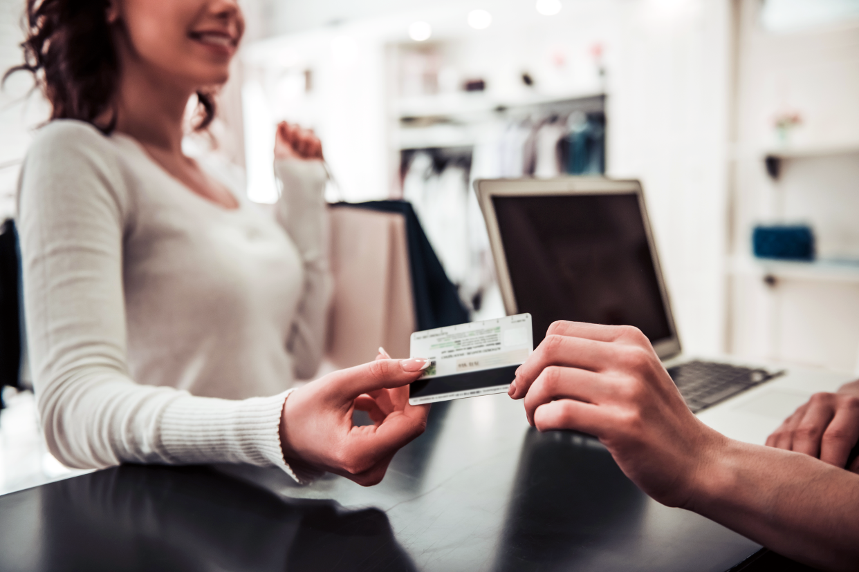Woman shopping in a retail store and paying with a credit card