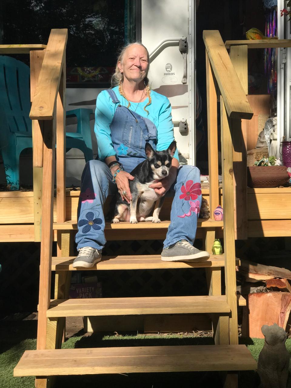 Cheryl Selby sits on her new porch at her new RV with her dog Freddie. Being part of Season for Caring in the past year made a huge impact on Selby. She now has an RV with heat and running water.