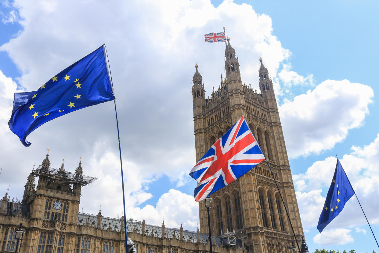 Low Angle View of British and European Union Flags Outside Parliament Buildings in London