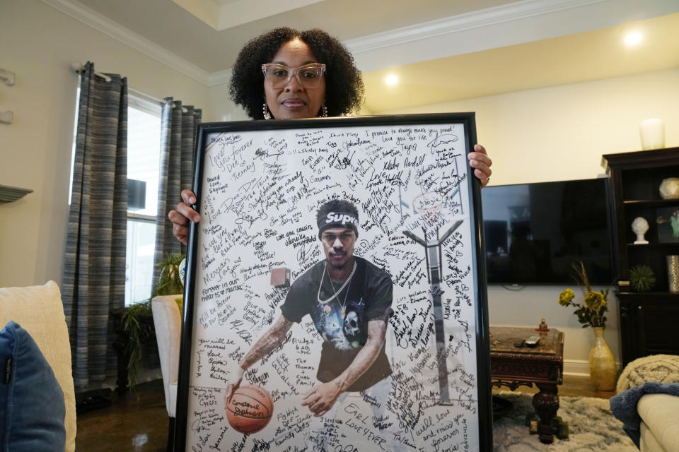 FILE - Pamela White poses in her home in Ponchatoula, La., with a photo of her son Dararius Evans, who was killed in January of 2020, Thursday, May 4, 2023. White and her family turned to Louisiana's victim compensation board for help paying for the unexpected funeral. The Justice Department proposed changes Monday, Feb. 5, 2024, to rules governing state-run programs that provide financial assistance to violent crime victims in order to address racial disparities and curb the number of subjective denials of compensation. (AP Photo/Gerald Herbert, File)