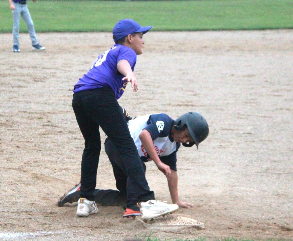 Quincy's Benny Travelbee slides safely into third while Bronson's Daniel Meja attempts the tag Monday