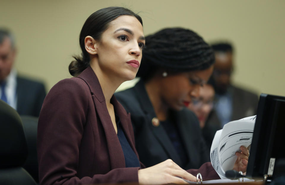 Rep. Alexandria Ocasio-Cortez, D-N.Y., left, looks over her notes during testimony by Michael Cohen, President Donald Trump's former lawyer, before the House Oversight and Reform Committee on Capitol Hill in Washington, Wednesday, Feb. 27, 2019. Sitting next to Ocasio-Cortez is Rep. Ayanna Pressley, D-Mass., right. (AP Photo/Pablo Martinez Monsivais)