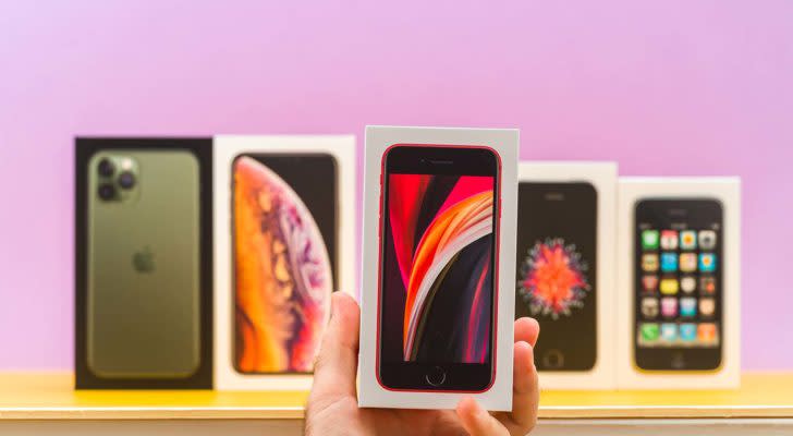 A close-up shot of different Apple (AAPL) iPhones in front of a purple background. stocks to buy
