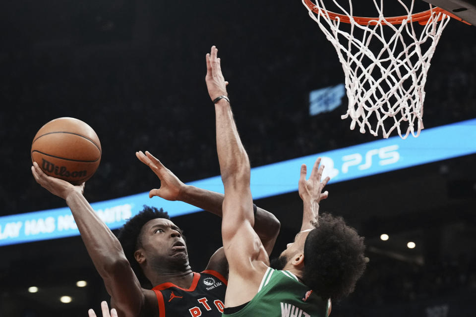 Toronto Raptors forward O.G. Anunoby, left, shoots on Boston Celtics Derrick White during the first half of an NBA basketball game in Toronto, Monday, Dec. 5, 2022. (Chris Young/The Canadian Press via AP)