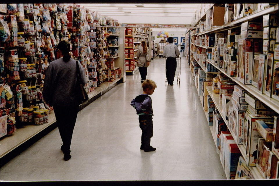 Photo of a little boy looking at toys inside a Toys "R" Us